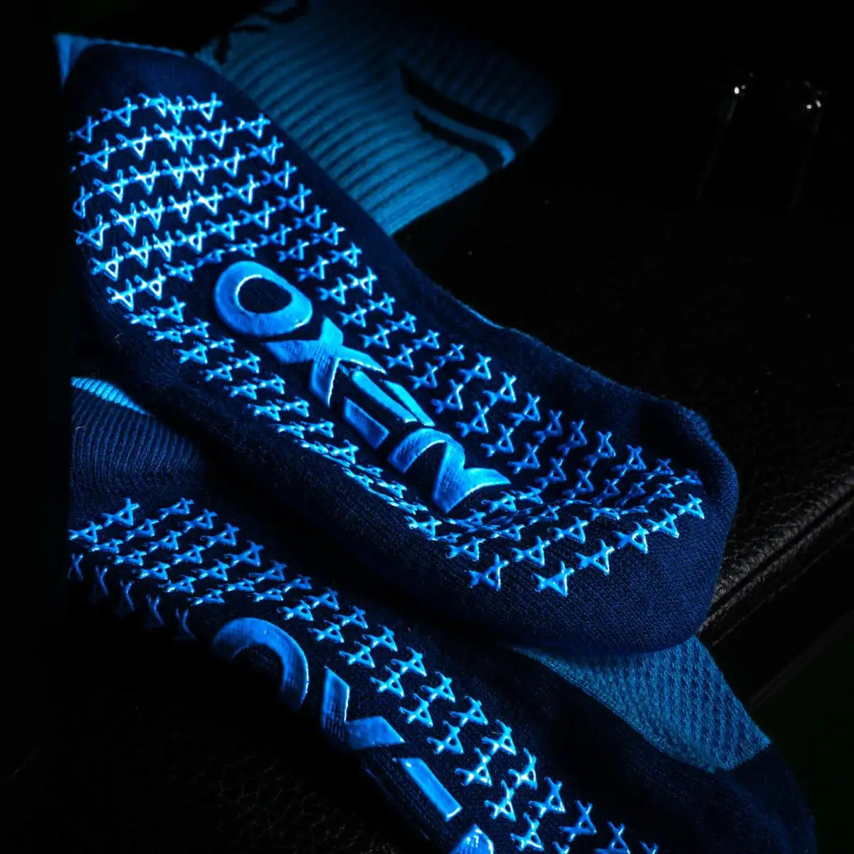Blue grip socks with Oxen brand logo on a dark background